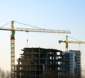 Aerial view of tower cranes and high residential apartment buildings under construction. Real estate development.