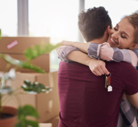 Happy couple with keys of new apartment