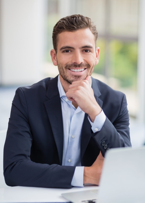 Portrait of businessman sitting with laptop at conference centre